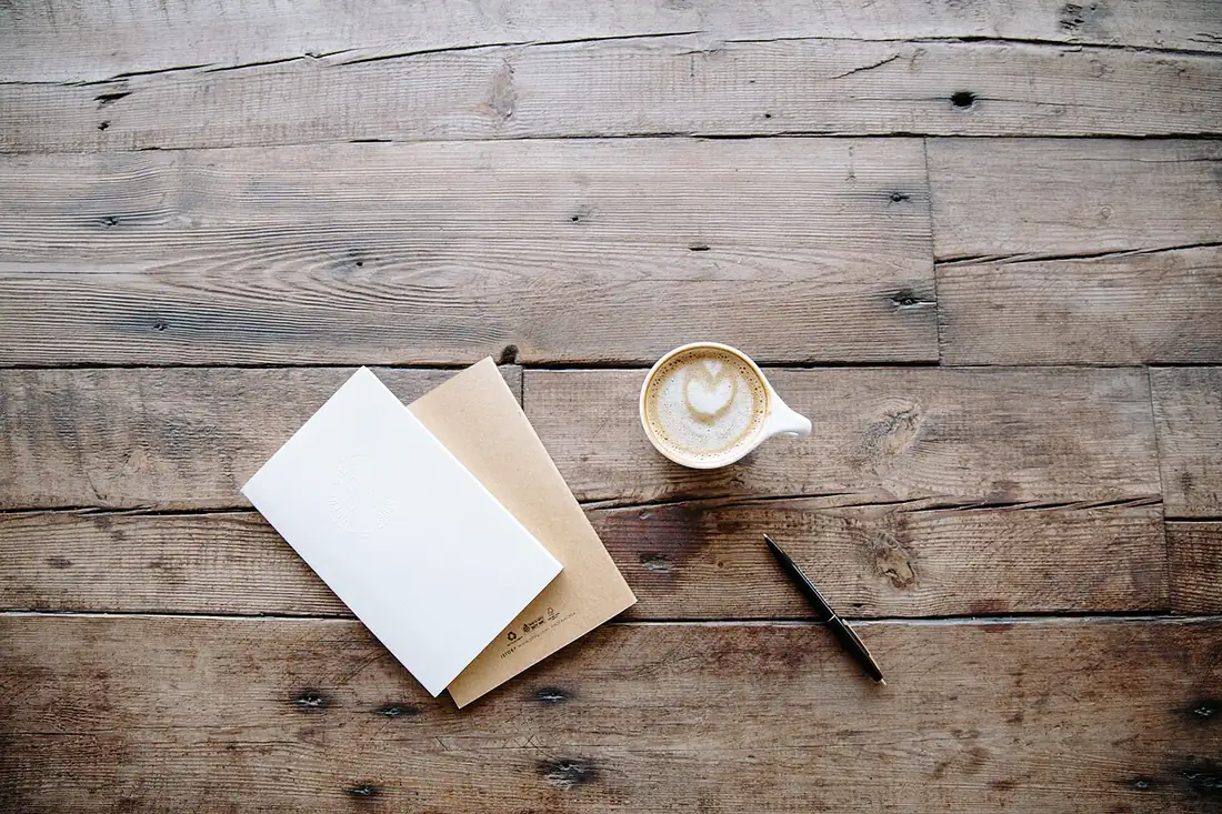 Koffie en notitieboekjes op een houten tafel