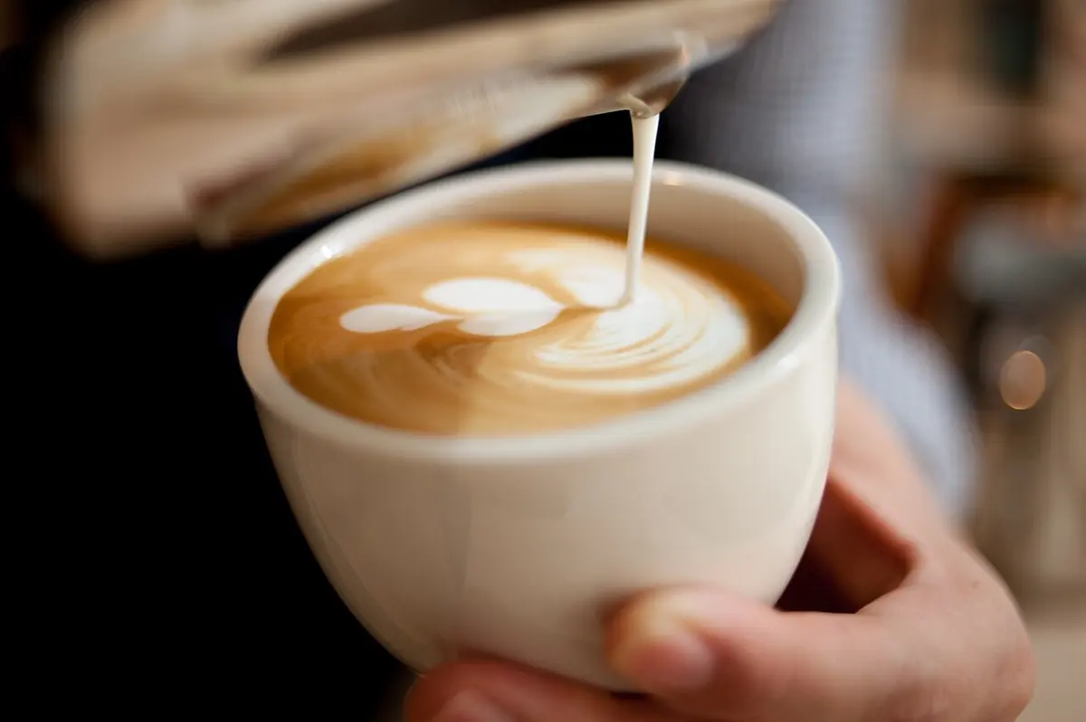 Milk poured into a cup of coffee