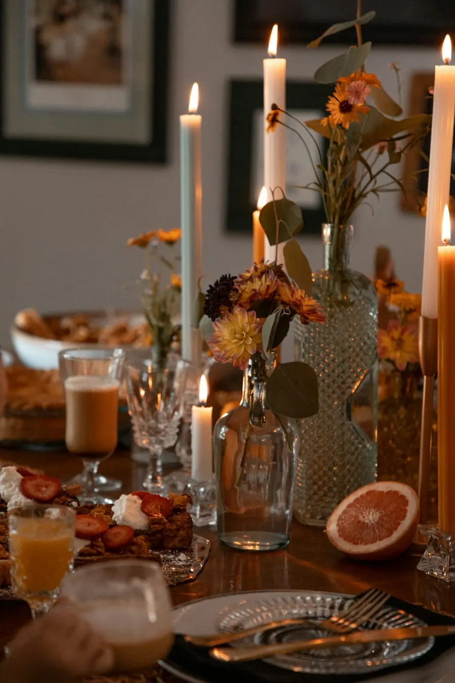 Een gedekte tafel met kaarsen en herfstbloemen